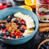 side-view-oatmeal-porridge-with-strawberries-blueberries-bananas-dried-fruits-nuts-ceramic-bowl-table (1) (3)_11zon